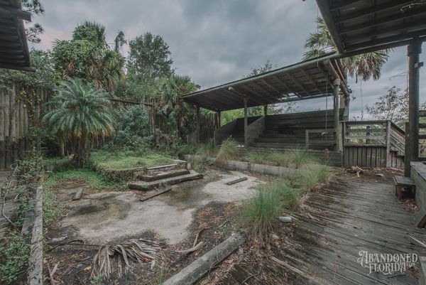 Empty animal enclosure and wooden decking under a covered viewing area at the abandoned Jungleland Zoo